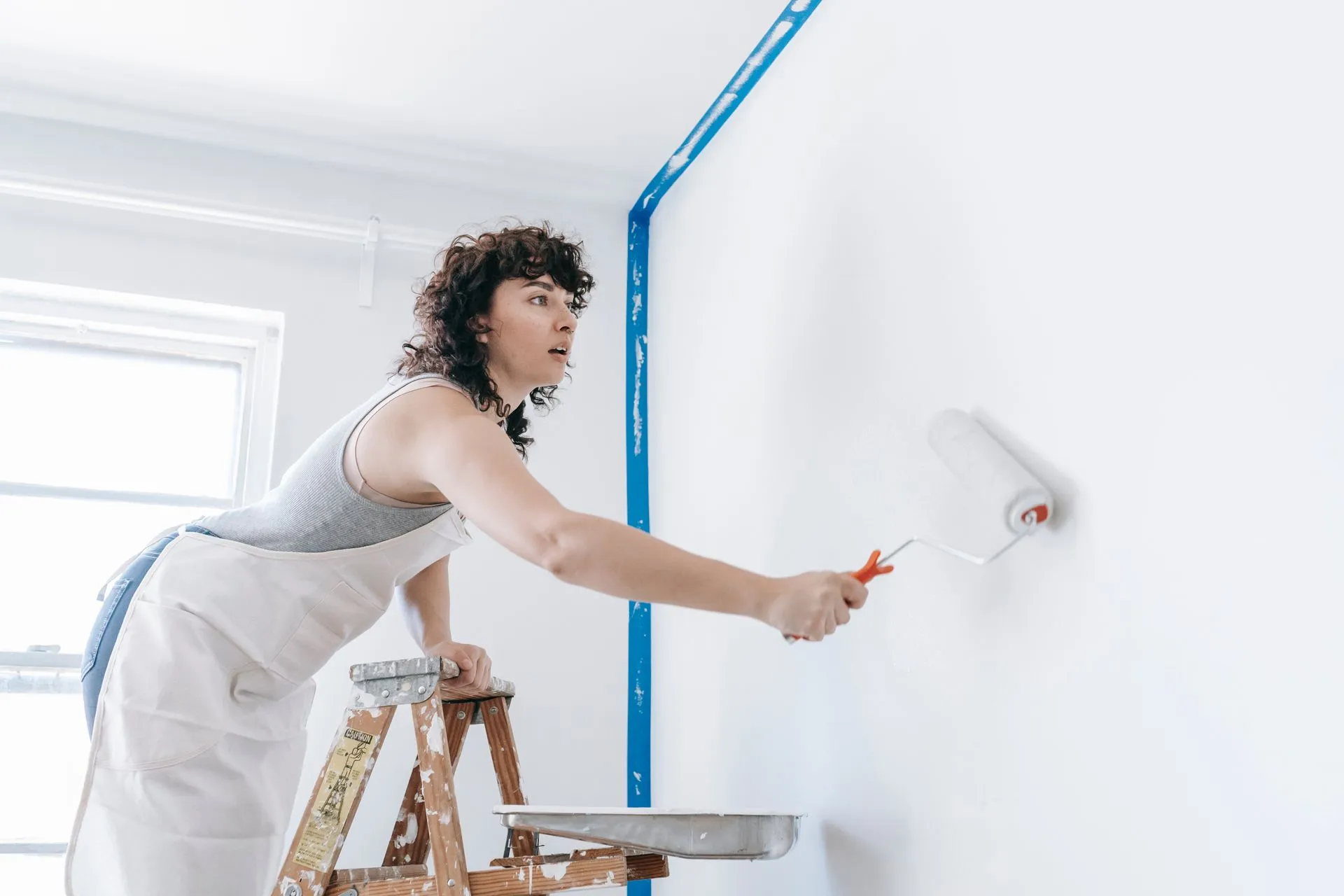 Decorator painting a wall white