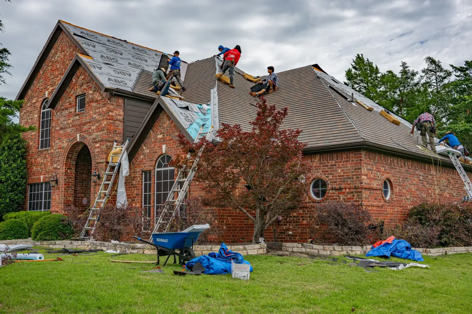 Roofers working on a brick house roof